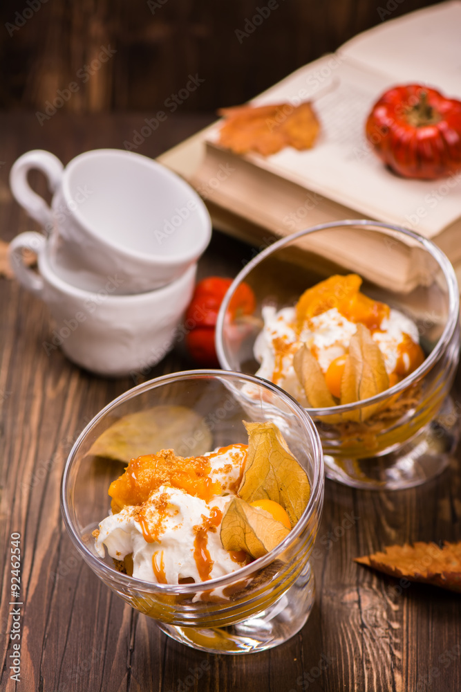 Delicious layered pumpkin dessert with cream, cookies, fruits an Delicious layered pumpkin dessert with cream, cookies, fruits an