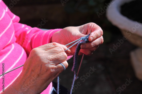 Woman knitting outdoor.
Senior lady outdoor in sunshine knitting.