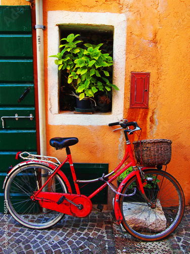 Traditional italian street with a red bicycles in Caorle old town.