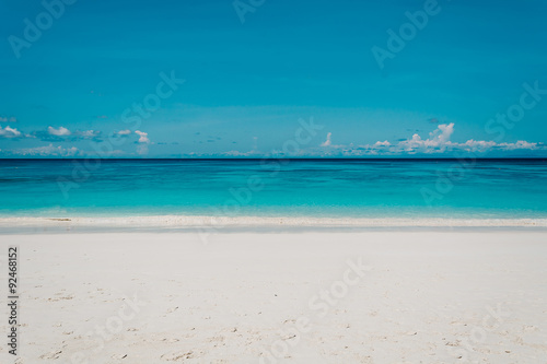 blue sky with sea and beach - soft focus with film filter