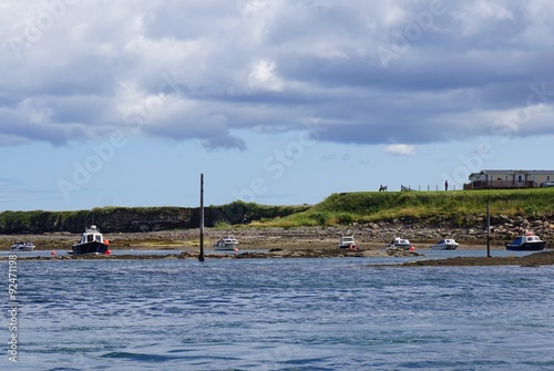 Small boats at low tide in the harbor at the coastal town of Seahouses, Northumberland, England