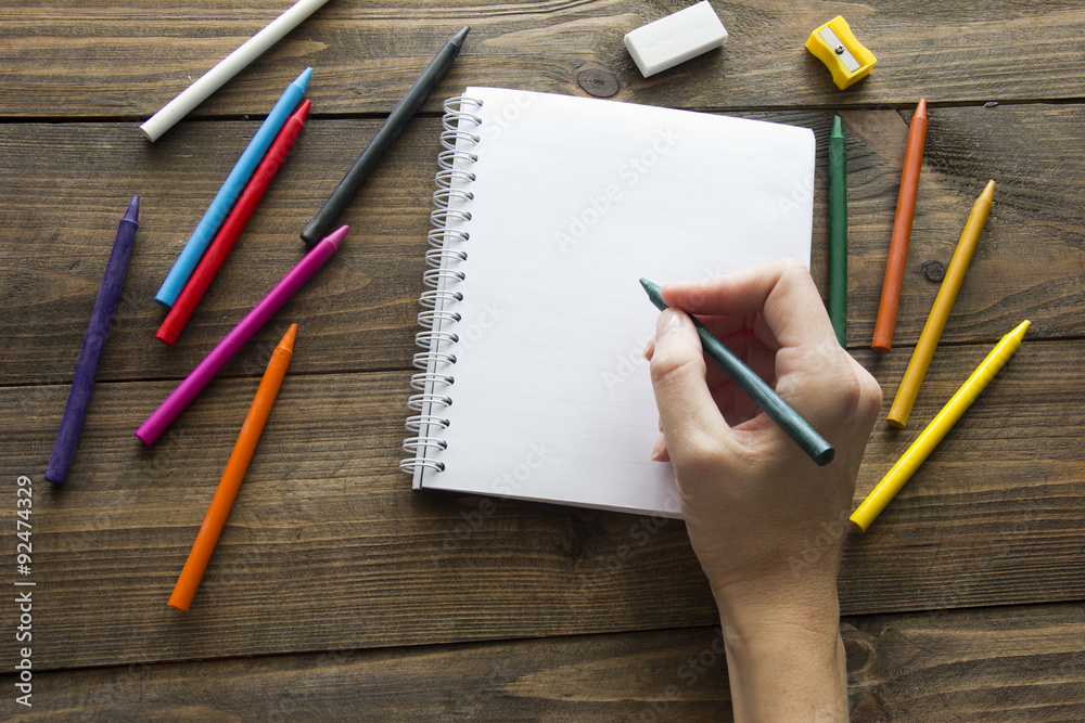 colored pencils , notebook and hand colored pencils , notebook and hand