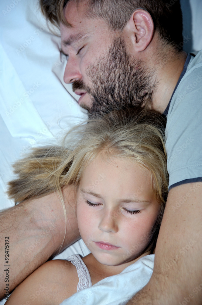 Dad and little girl sleeping together on bed Dad and little girl sleeping together on bed