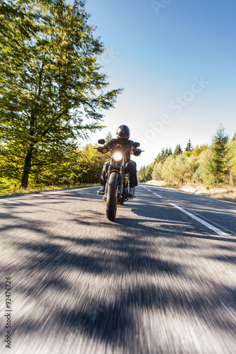 Man seat on the motorcycle on the road in forest.