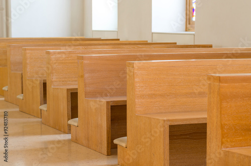 Modern empty wooden church pews photo