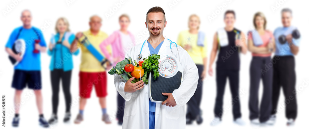 Doctor with vegetables and group of fitness people.