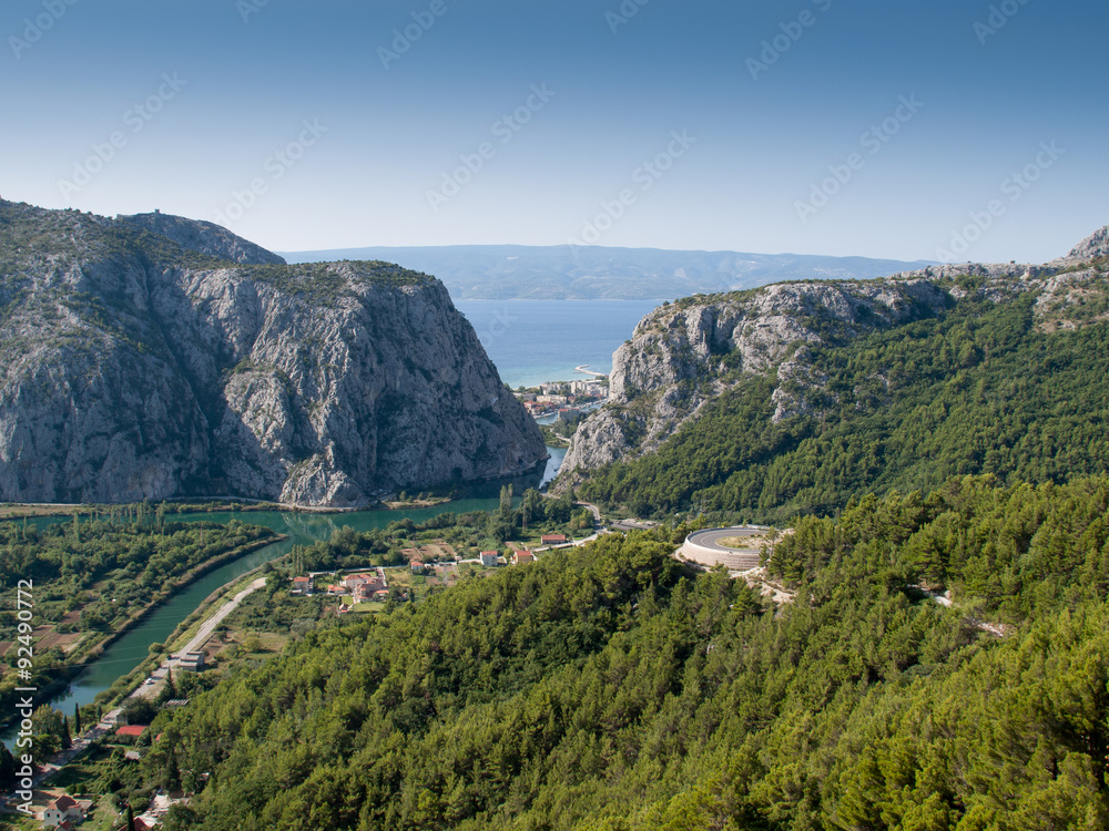 View to Omis from the mountains with the river Cetina, the town, the adriatic sea and in the background the island of Brac with a clear blue sky.