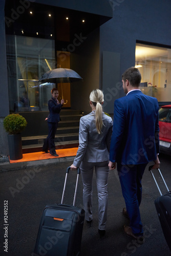 business people couple entering hotel