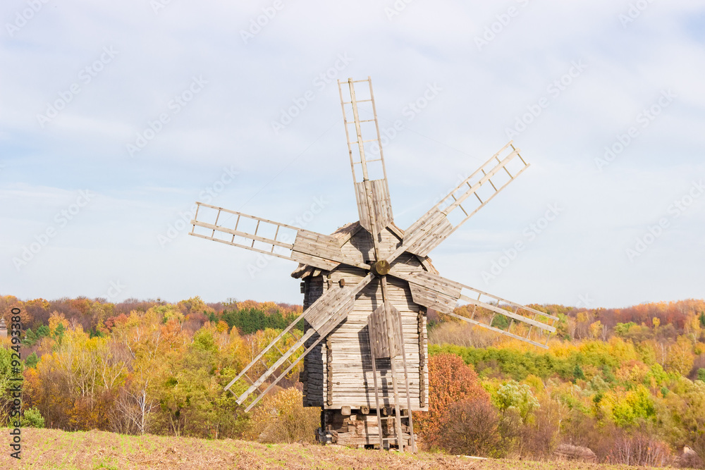 Old windmill on a background of forest and sky