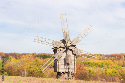 Old windmill on a background of forest and sky