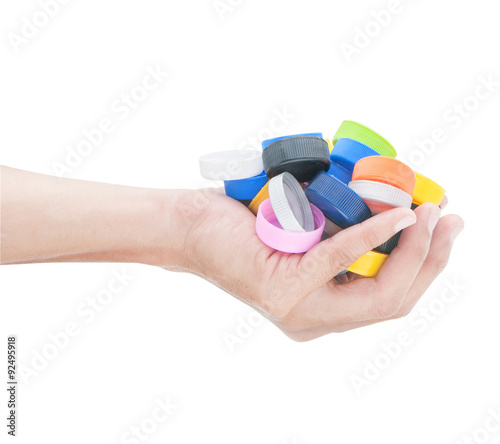 Hand holding many colorful  bottle cap of water on white backgro photo