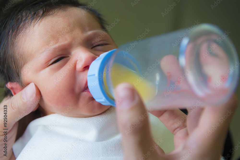 Bebé recién nacido en etapa de lactancia toma primer biberón de leche de  apoyo ofrecido por la madre Stock Photo