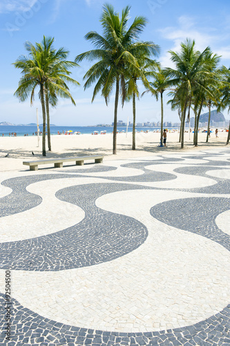 Iconic sidewalk tile pattern with palm trees at Copacabana Beach Rio de Janeiro Brazil