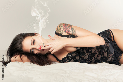 brunette girl in bed with cigarette