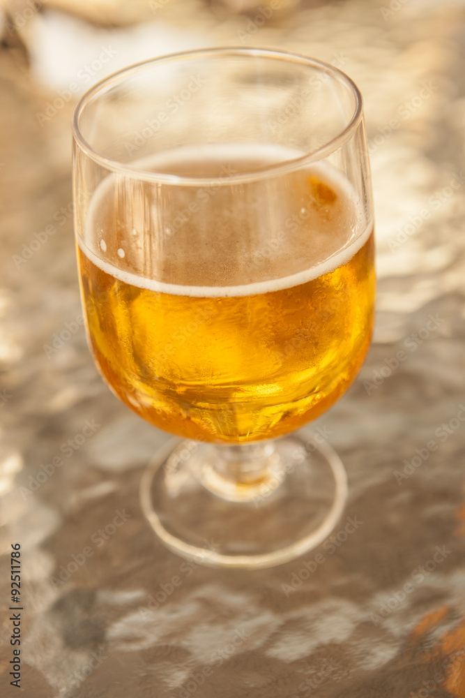 Misted glass of beer on a glass table in a bar Misted glass of beer on a glass table in a bar