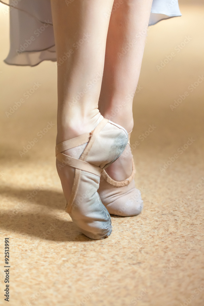 The close-up feet of young ballerina in  old pointe shoes 