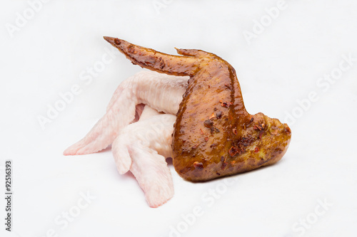 fried and raw chickens on white background