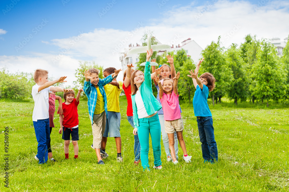 Obraz premium Happy kids reach after white airplane toy