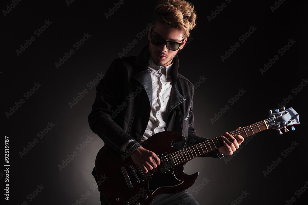 Obraz premium dramatic picture of a young rock and roll guitarist