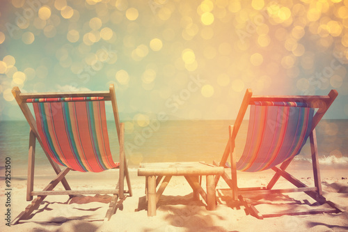 Beach chairs on sea shore with glowing bokeh and film stylized  double exposure effect