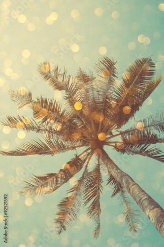 Vintage color stylized palm tree with bright party bokeh light overlay, double exposure effect