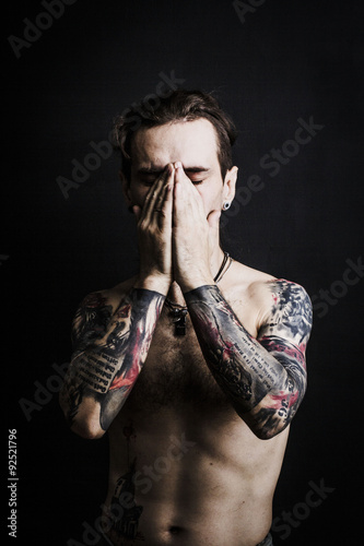 Portrait of a man with naked torso and tattooes