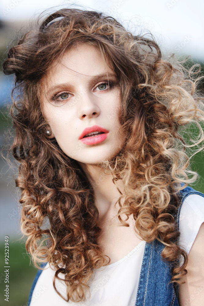 Fototapeta premium close-up portrait of a beautiful young girl with curly brown hai