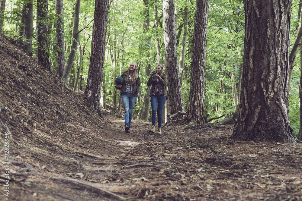 Twin sister walking on forest trail. Walking towards camera.