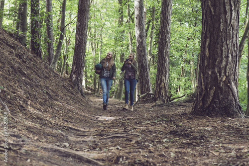 Twin sister walking on forest trail. Walking towards camera.