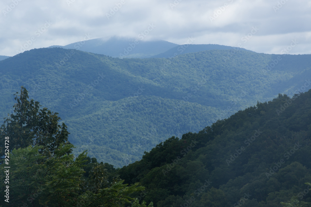 Naklejka premium Morning mountains with clouds and mist