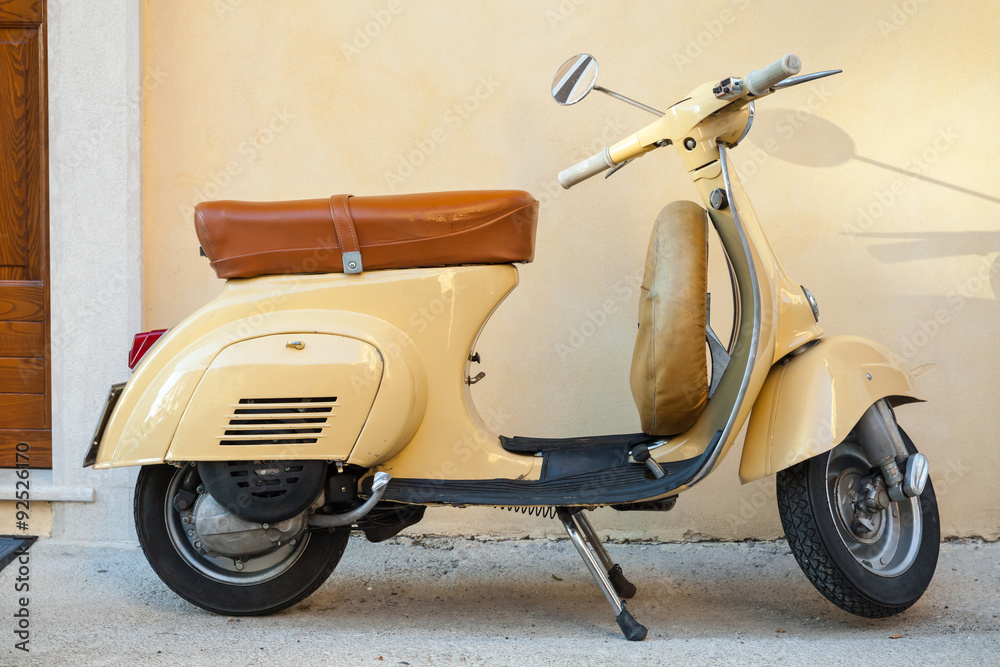 Naklejka premium Classic yellow scooter near the wall