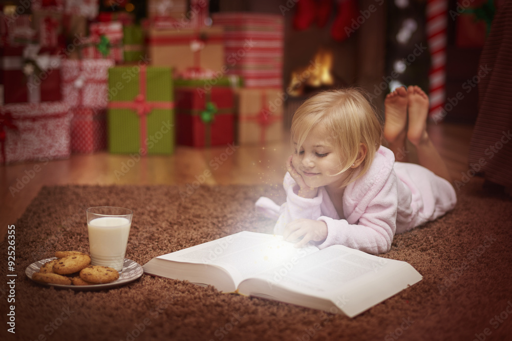 Fototapeta premium Little girl reading book about amazing adventures