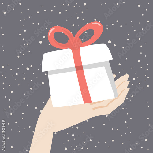 Hand is holding christmas gift with red ribbon on the snowing background. Christmas vector illustration. 