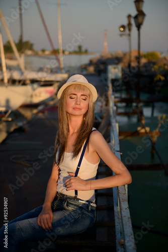 The beautiful girl on walk on the yacht club mooring