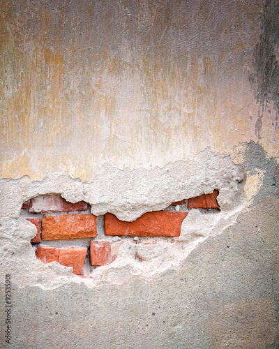 Old bricks wall with cracked stucco layer