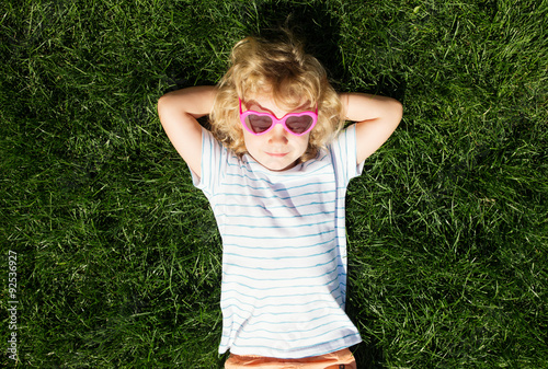Portrait of a smiling little girl in heart shaped sunglasses lyi