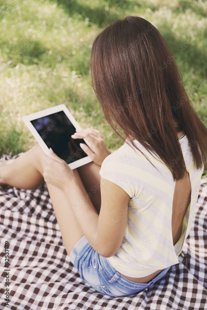 Fototapeta premium Beautiful young girl with tablet in park
