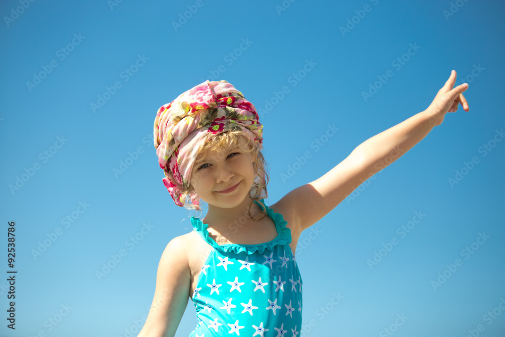 Cute little girl in swimwear against blue sky, outdoor portrait Cute little girl in swimwear against blue sky, outdoor portrait