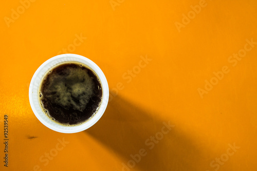 Cup of black coffee on the orange background.