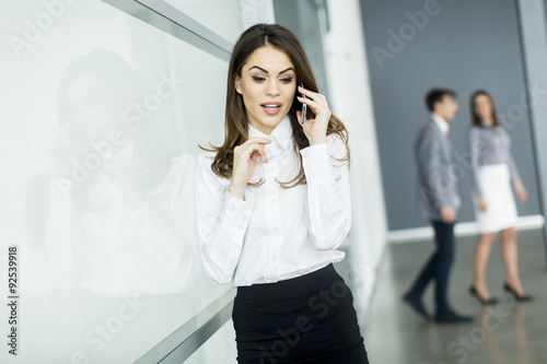 Young woman in office with mobile phone