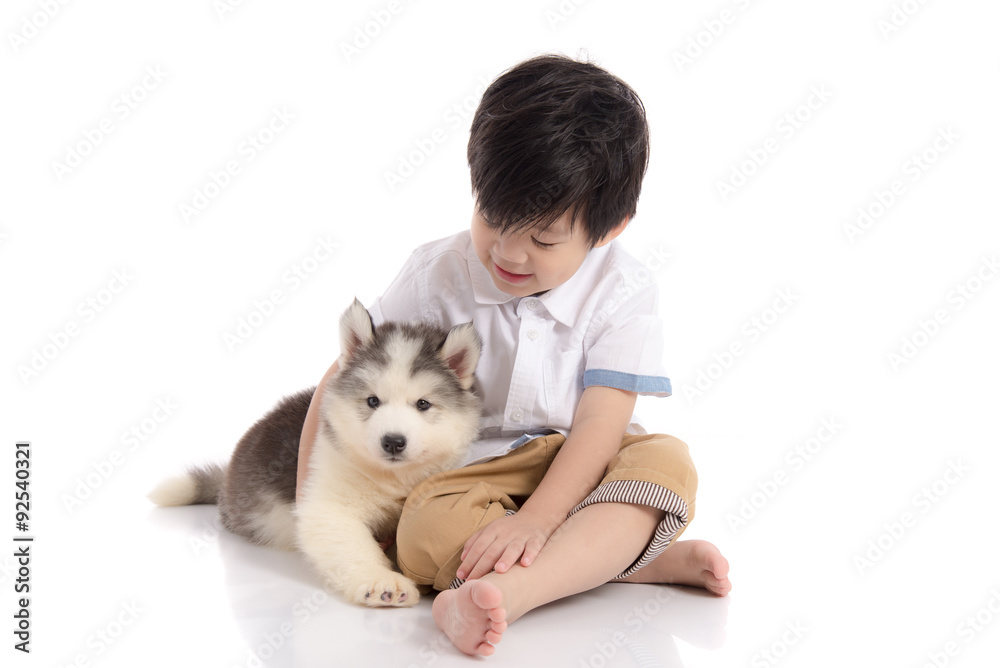 Cute asian boy sitting with siberian husky puppy Cute asian boy sitting with siberian husky puppy