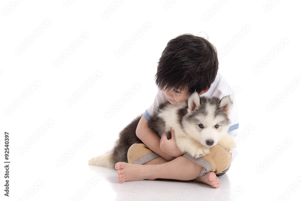 Cute asian boy sitting with siberian husky puppy
