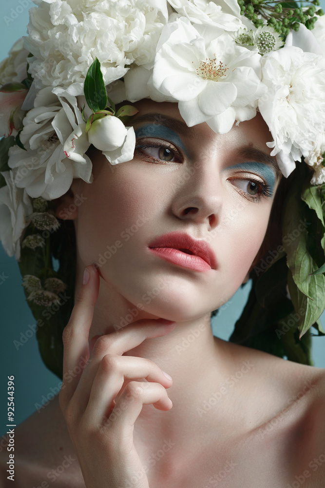 Portrait of a beautiful young girl with flowers on her head, concept beauty