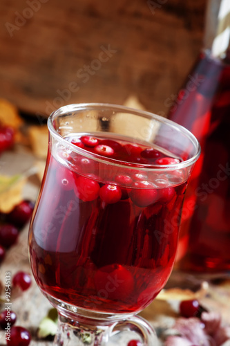 Hot mulled wine with cranberries on the background of autumn, se