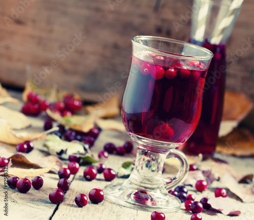 Hot mulled wine with cranberries on the background of autumn, se