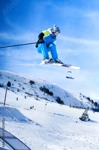 Jumping skier against blue sky
