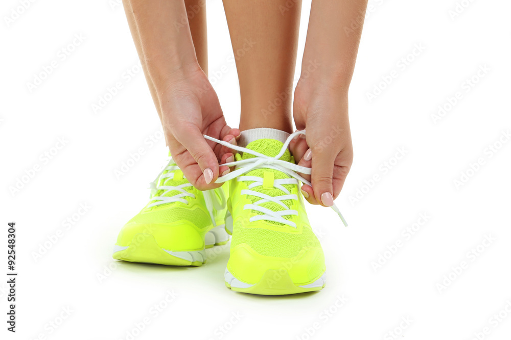 Sneakers on women legs on a white background Sneakers on women legs on a white background
