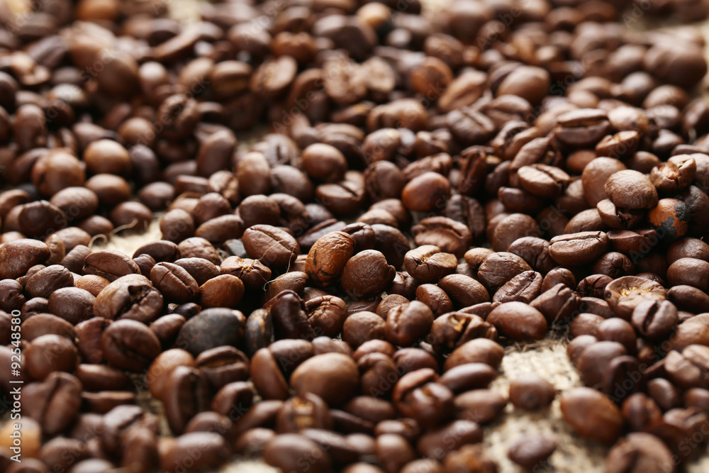 Fototapeta premium Roasted coffee beans on a sack, close up