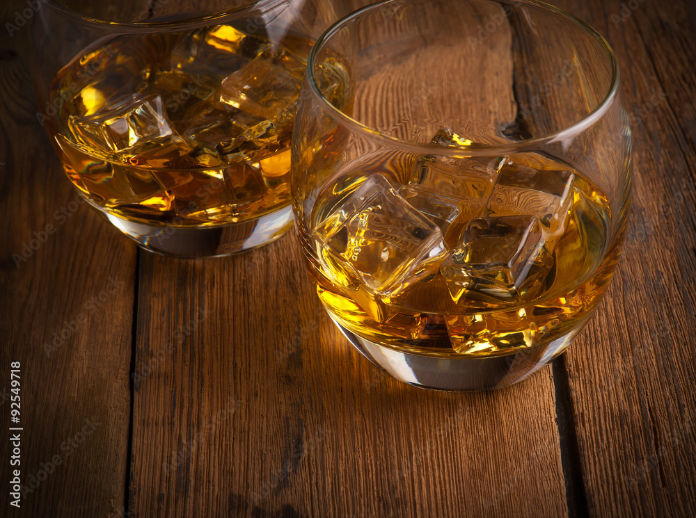 Glowing cognac or brandy in an elegant snifter glass on an old dark wooden bar counter with copyspace Glowing cognac or brandy in an elegant snifter glass on an old dark wooden bar counter with copyspace