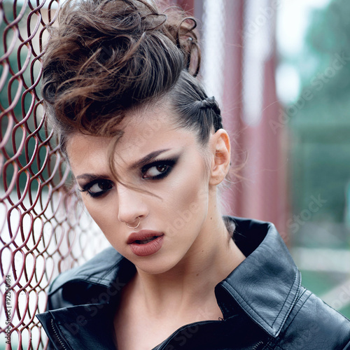 Portrait of a beautiful brunette girl with a mohawk, rock style, outdoors